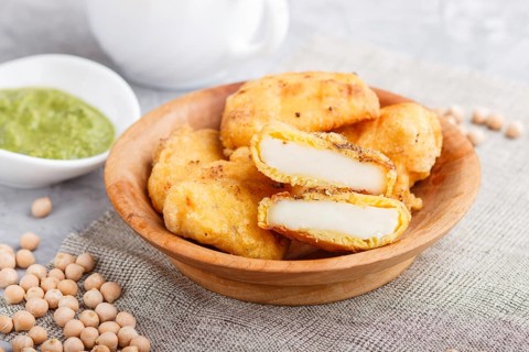 Traditional indian food paneer pakora in wooden plate with mint chutney on a gray concrete