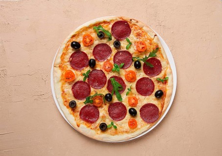 Pepperoni pizza, with olives and cherry, homemade, on a beige background, top view, no people
