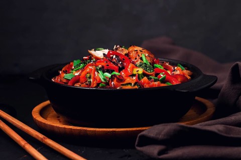 Asian cuisine, teriyaki meat with vegetables, in a cast-iron frying pan, close-up, no people