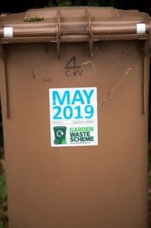 May 2019 date sticker on garden waste scheme brown compost collection bin, East Suffolk, England,