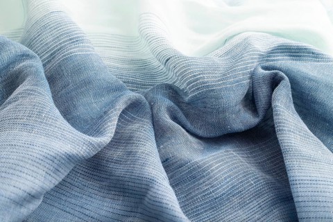 Fragment of blue linen tissue. Side view, natural textile background and texture. wave concept,