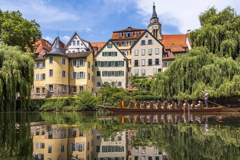 Neckarfront Tübingen with punt on the Neckar. Postcard motif with historic buildings, collegiate