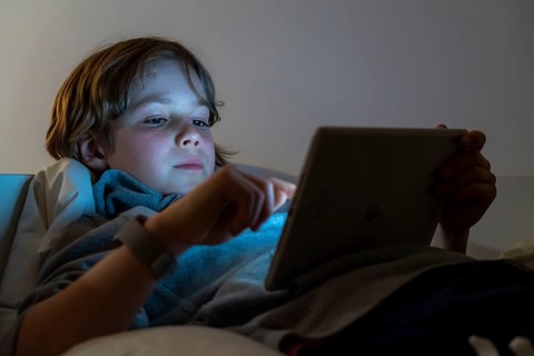 A boy plays computer games on a tablet PC