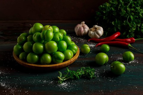Tkemali, green cherry plum, with ingredients for sauce, cilantro, mint, hot pepper, garlic, on a