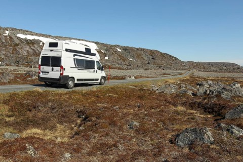 Campervan/caravan on a lonely coastal road through the tundra near Hamningberg on the Barents Sea,