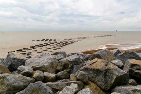 Fishtail reef coastal defences and rock armour at high tide, Cobbold's Point, Felixstowe, England,