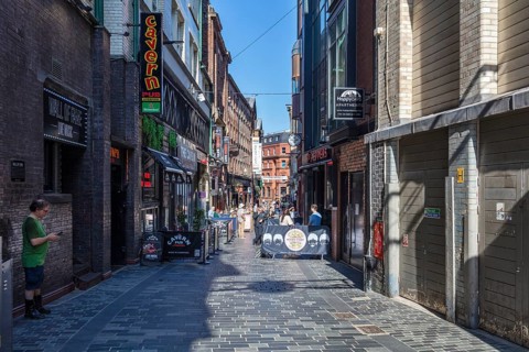 Narrow alley with shops and pubs, lively with passers-by, Liverpool