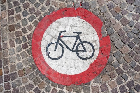 Pictogram for cycling prohibited painted on a cobblestone pavement in the old town centre of