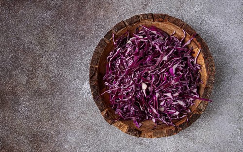 Red cabbage, sliced, in a wooden salad bowl, top view, no people