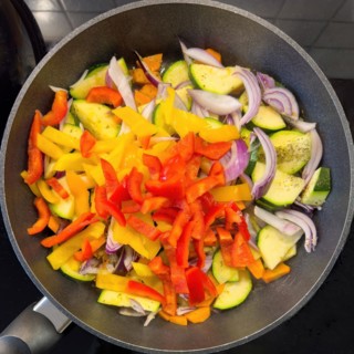 Vegetarian vegan dish Vegetable pan with courgettes red yellow peppers onions vegetable onions