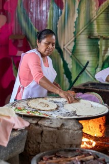 Santa María del Tule, Oaxaca, Mexico, A worker at the Restaurant Familiar Reynita cooks on a comal
