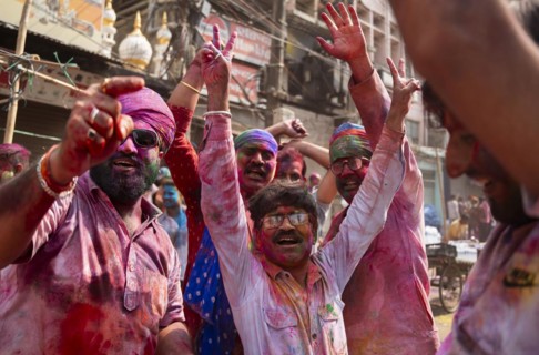 Revellers dancing in the beat of music as they celebrate Holi on a street, the Hindu spring