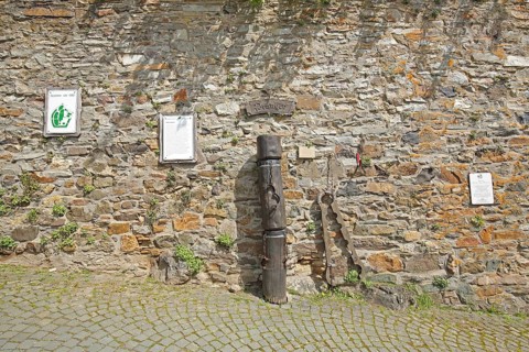 Historical pillory, pillory on stone wall, Middle Ages, inscription, text, explanation, town hall