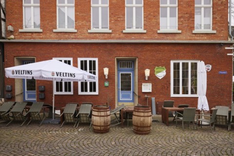 Outdoor area of a catering establishment with old beer barrels as decoration, tables and chairs as