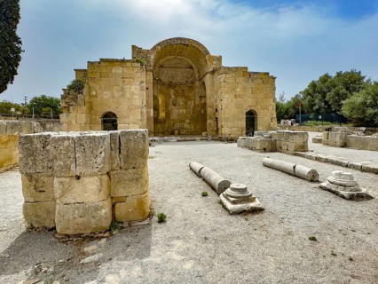 View of ancient ruins of Titus Basilica, in the foreground remains of stones foundation walls of