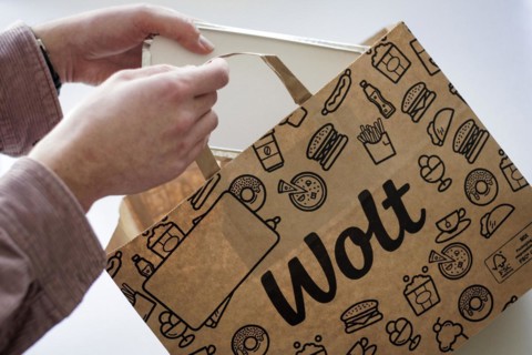 A person takes an order from a paper bag from the delivery service Wolt. Berlin, 28.03.2024