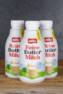 Pure buttermilk from the company Theo Müller on wooden board with text free space Copyspace
