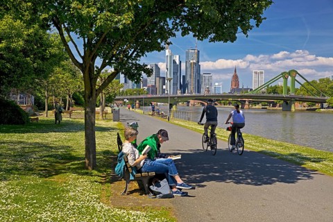 People seeking relaxation in fine weather on the Main promenade in front of the Flößerbrücke,