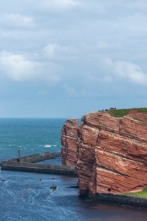 Red coloured sandstone, steep cliff coast of the offshore island of Heligoland, home of the