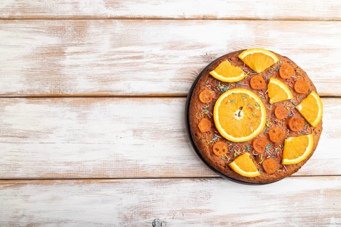 Orange cake on a white wooden background. Top view, flat lay, copy space