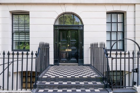 Elegant house entrance with solid black front door and white façade, Holborn, London Borough of