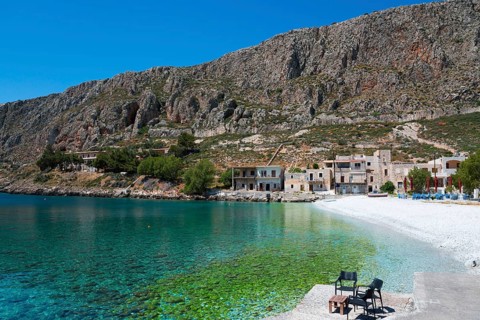 Secluded bay with crystal clear water and houses under steep mountains, Geromilenas, Mani, Laconia,