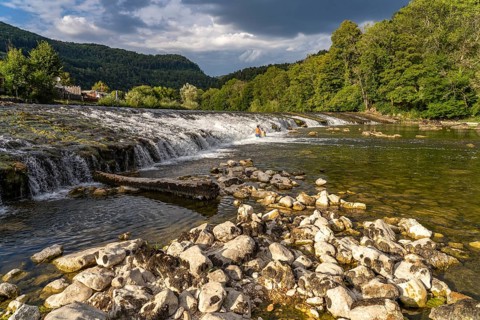 Children bathing at the weir in the Doubs river near Ocourt, Switzerland, Europe