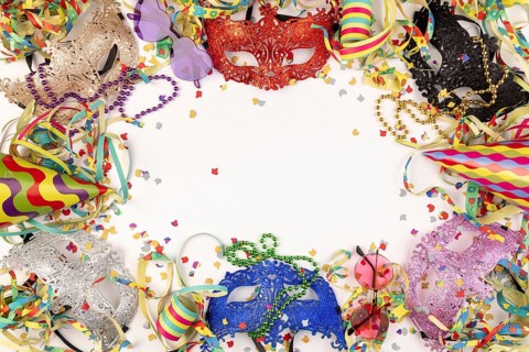 Colourful masks, paper streamers, confetti and party hats on a white background, carnival