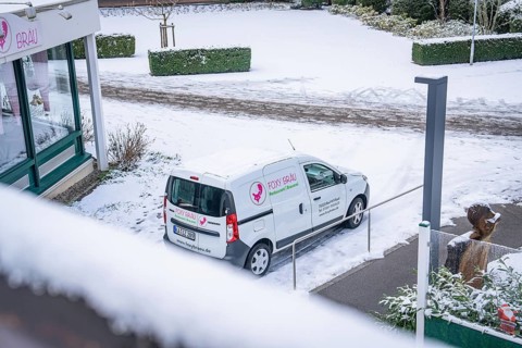Snow-covered car park with delivery van at a shop, wintry atmosphere, spa garden, Bad Wildbad,