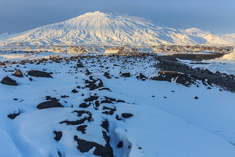 Rocks, lava field and surf at the coast, evening light, sun, snow, winter, Arnarstapi,