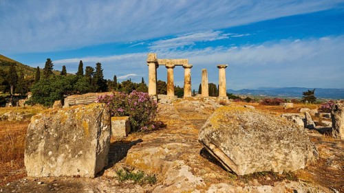 Archaic Temple of Apollo, Doric columns, path leading to ruins with blooming flowers in the