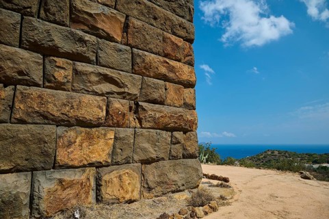 Ancient ruined wall in dry landscape overlooking the sea on a sunny day, Palaiokastro, Ancient