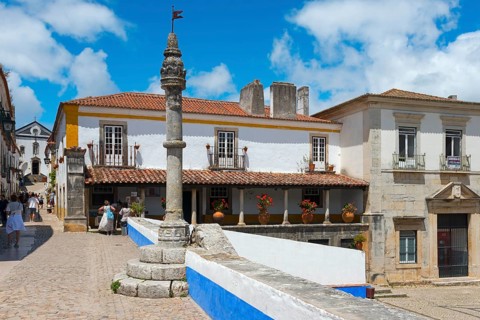 Idyllic street scene with old buildings, café and relaxed passers-by, Pelourinho de Óbidos,