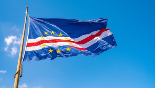 The flag of Cape Verde flutters in the wind, isolated against a blue sky