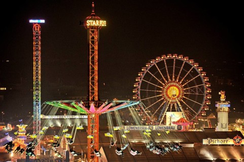 View over the Wies'n at night with illuminated carousel, Ferris wheel, stalls, beer tents and