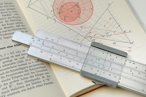 Slide rule on book, calculating aid