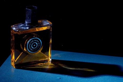 Bottle with aftershave in dark light, elegant style with blue background