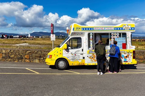 Tourists at the ice cream van, ice cream car, ice cream cones for sale at the roadside, spring