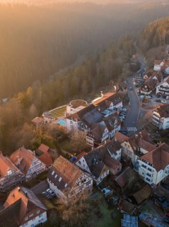View of a village with half-timbered houses at sunrise in a hilly wooded area, Zavelstein, district