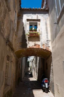 Narrow cobbled alley with flowers at the window and motorbike, Old Town, Krk Town, Krk Island,