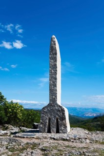 Stone pillar in a wooded landscape rising against a clear blue sky, Glagolitsa, the oldest script