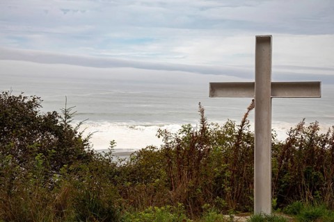 Klamath, California - A cross stands on a hill above the Pacific Ocean near a small cemetery on the