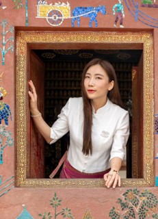 Woman looks out the window at Wat Xieng Thong, Luang Prabang, Laos, Asia