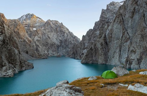 Wild camping, camping in the wilderness with a tent in front of mountain lake Kol Suu, Sary Beles