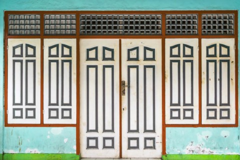 Closed, dilapidated building with peeled off house wall in turquoise colour, pastel, green,