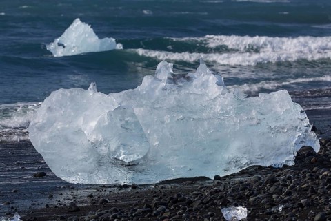 Little icebergs and crushed ice on the black beach at Joekulsarlon glacial lake
