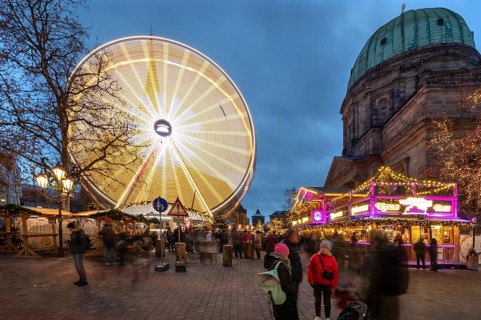 Ferris wheel at the winter village, Christmas market at dusk, St Elisabeth's Church on the right,