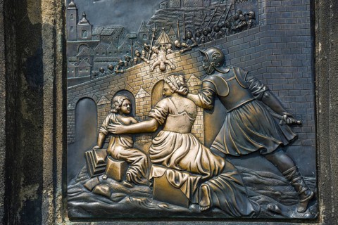 Bronze relief, Saint Nepomuk falling over the bridge, laying hands on the relief in the pillar is