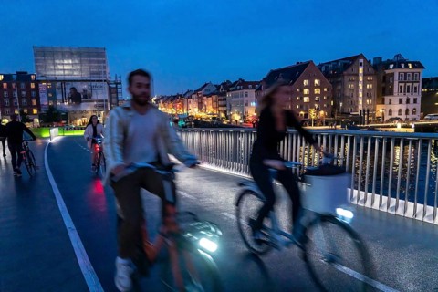 Cyclists on the Inderhavnsbroen cycle and footpath bridge, across the harbour, at night, at Nyhavn,