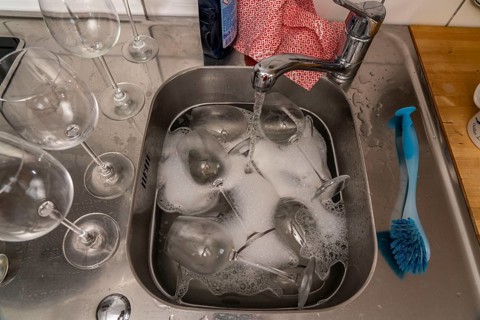 Kitchen after a big dinner, cooking party, sink with dirty glasses, sink